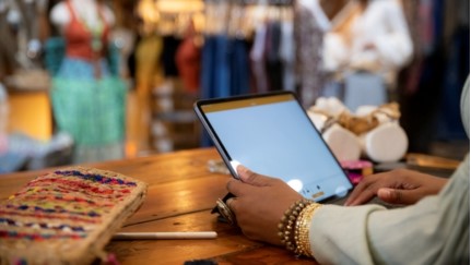 woman at clothing store counter on tablet