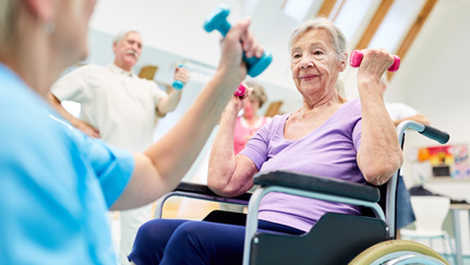 Elderly woman in a wheelchair doing aerobic arm curl expercises