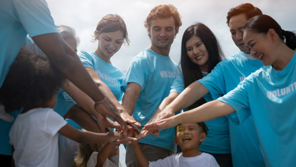 Seven volunteer wearing matching blue volunteer shirt in circle