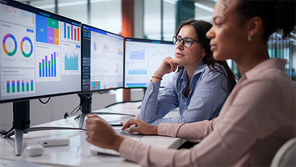 Two professionals reviewing AI generated data dashboards