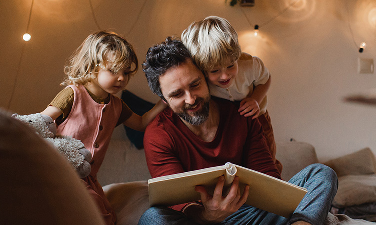 A little girl sitting on a porch swing next to her father