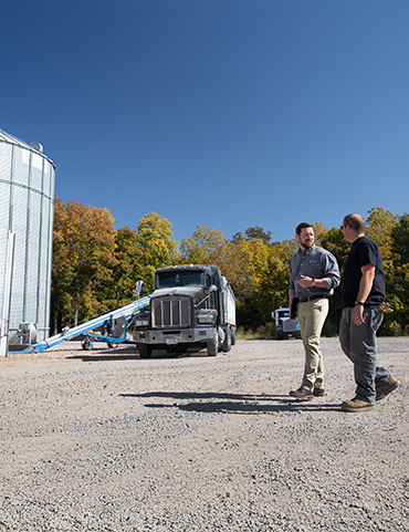 two men walking on a farm