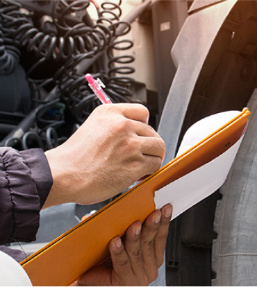 vehicle inspector writes on clipboard