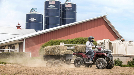 ATV hauling hay bales on farm