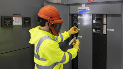 Worker locking out an electrical breaker.
