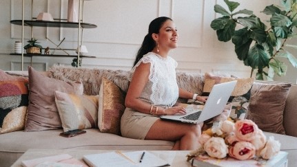 Businesswoman sitting on couch with laptop