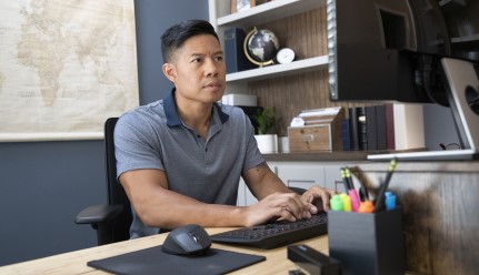 Hombre sentado en un escritorio trabajando en su computadora