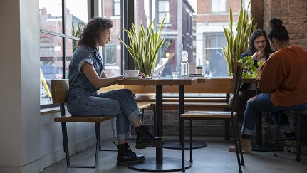 Mujer en una cafetería mirando su computadora