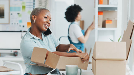Two individuals behind a counter in a cafe or coffee shop.