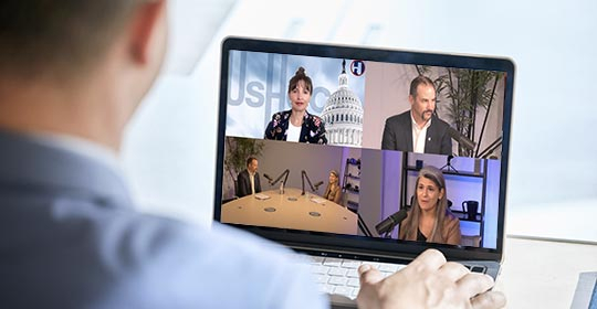 business owner watching a video roundtable discussion on his laptop