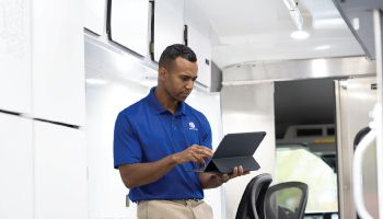 risk management expert standing and typing on laptop