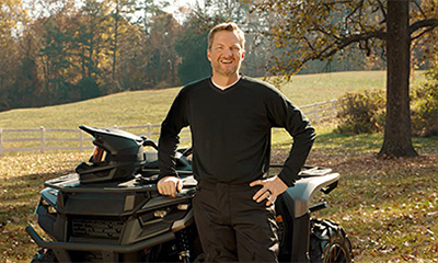 dale earnhardt jr standing next to an ATV