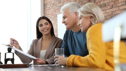 A financial professional meets with an older couple to review documents.