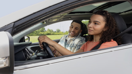 Teen driving with her father.