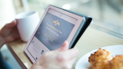 lectura desde una tableta móvil junto a la vidriera de una cafetería