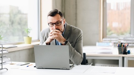 hombre mirando una computadora portátil