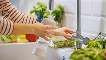 filling up a water bottle in the kitchen sink