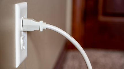 An electrical outlet sparks as a device is plugged in.