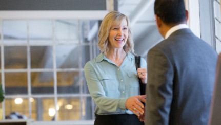 Woman shaking hands with a man in a gray suit