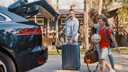 familia subiendo maletas a su auto para las vacaciones