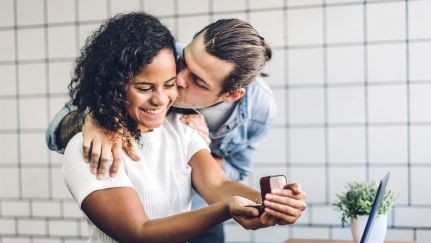 A couple joyfully embracing while looking at their valuable jewelry.