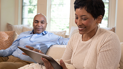 Couple at home looking at their laptop