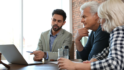 Male advisor working with mature couple in office.