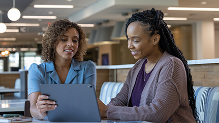 A financial professional and client review finances on a tablet together.