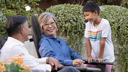 retired couple sitting in chairs next to their grandson