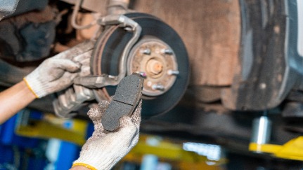 Someone performing maintenance on a car brake. 