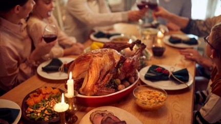 A family enjoying a holiday meal at a dining table.
