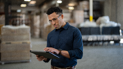 hombre trabajando con una tableta en un depósito