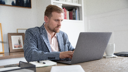 hombre trabajando en su computadora portátil en la oficina de su casa