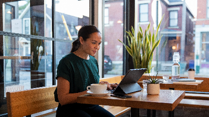 mujer en una cafetería mirando su tableta