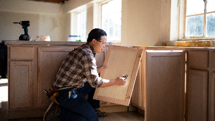 cabinet worker installing cabinets in a kitchen
