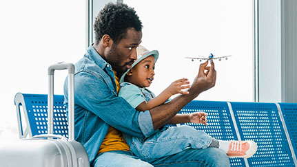 Father and child in airport with toy airplane