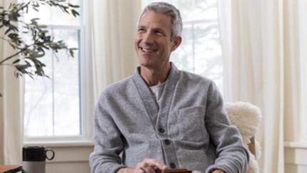 Man sitting in a chair using his phone