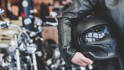 motorcycle rider carrying helmet