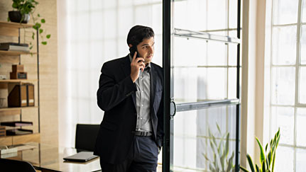 man standing in his office talking on his cell phone