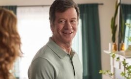 Man smiling while talking with someone in a cozy living room