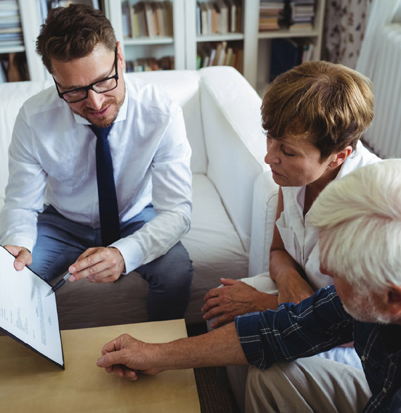 Couple sitting with their financial professional and looking over documents