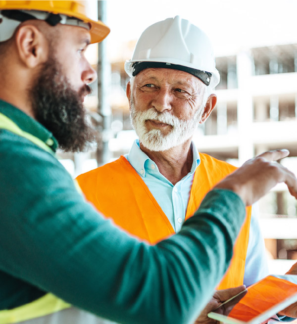 Two construction workers talking outside.