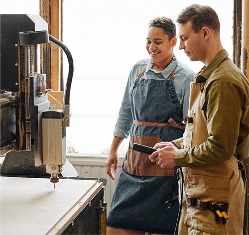 Two people working at a business using machinery.