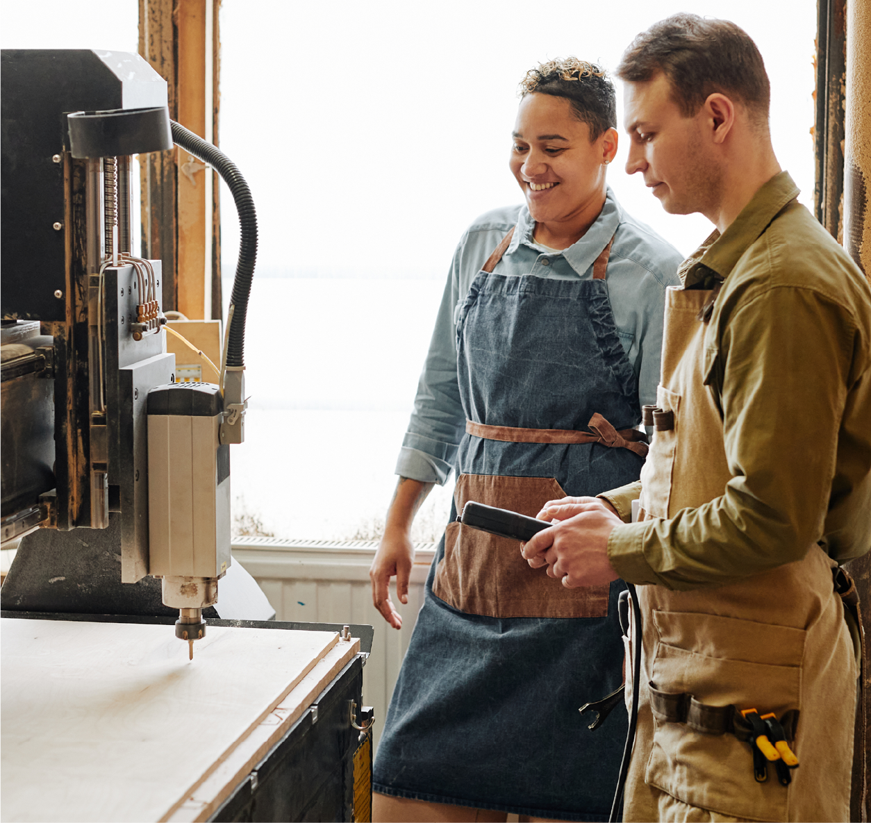 Two people working at a business using machinery.