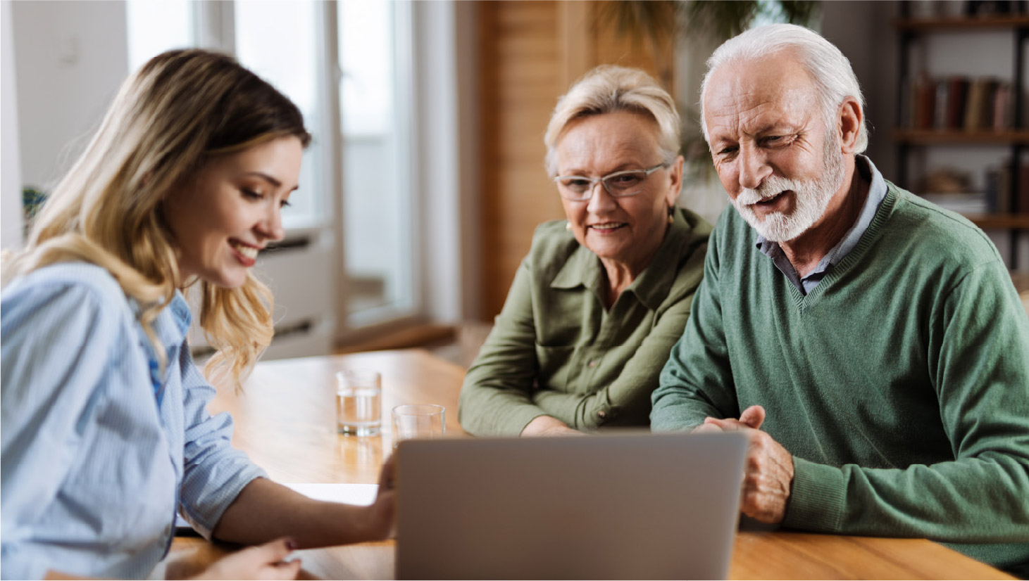 Couple in their upper 60s looking at a laptop with their financial professional.