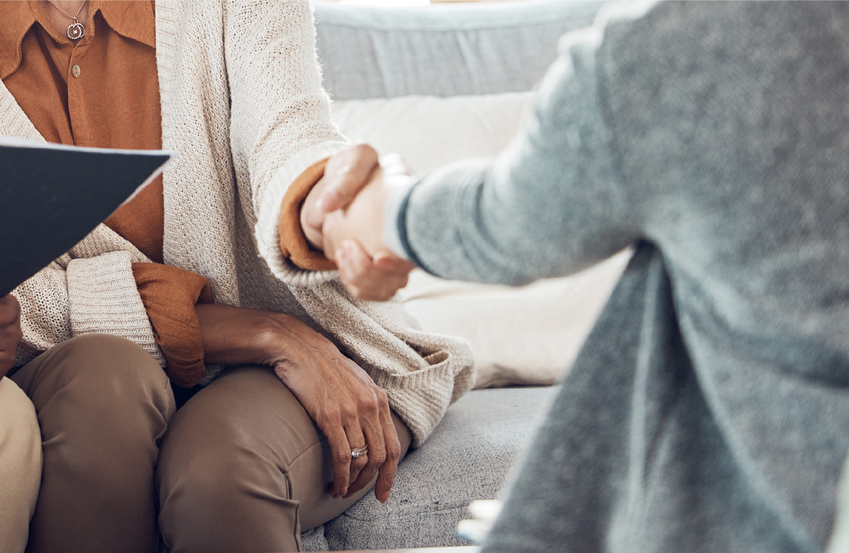 2 people sitting down shaking hands