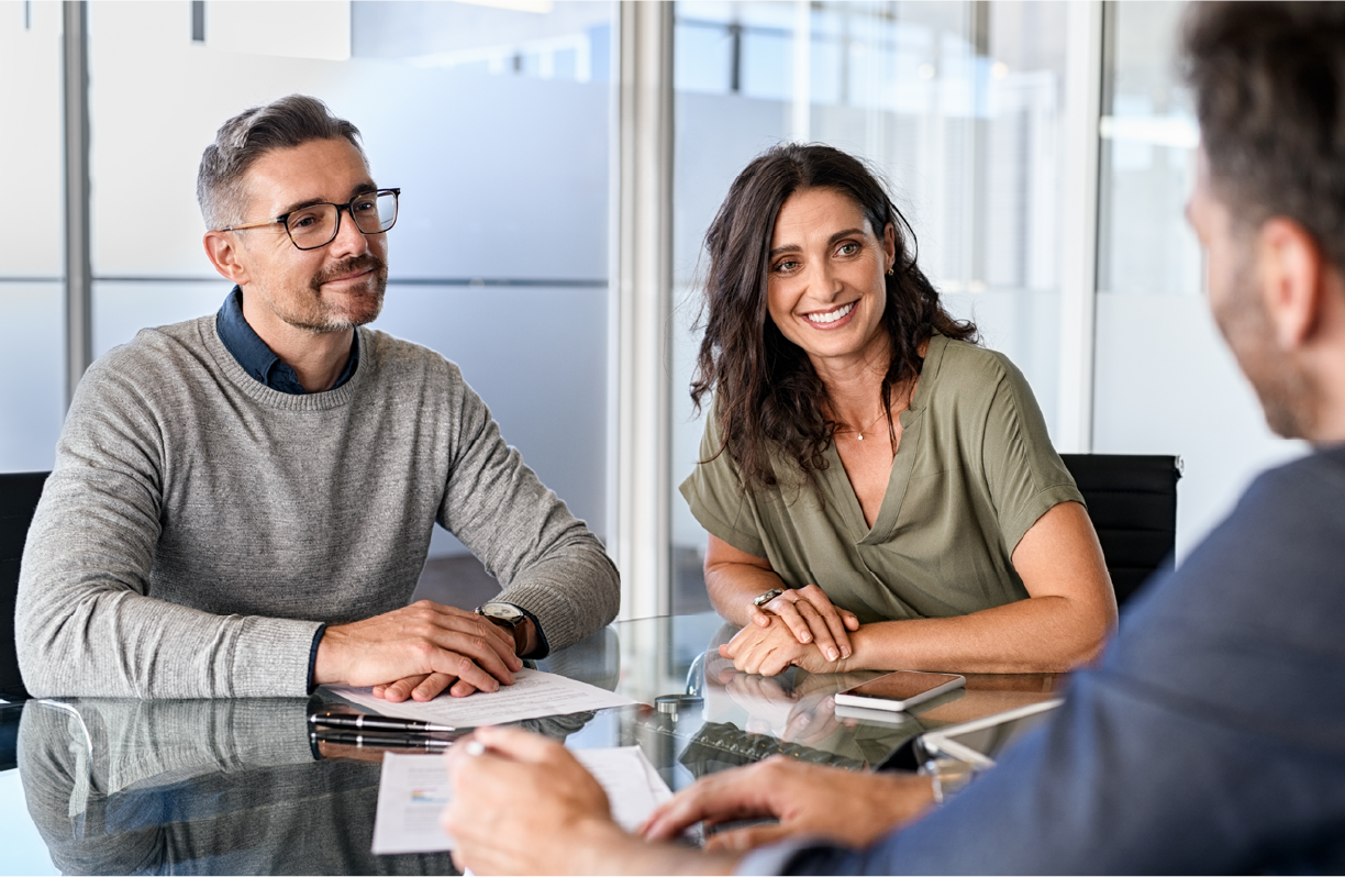 Couple talking with a Financial Professional sitting at a desk