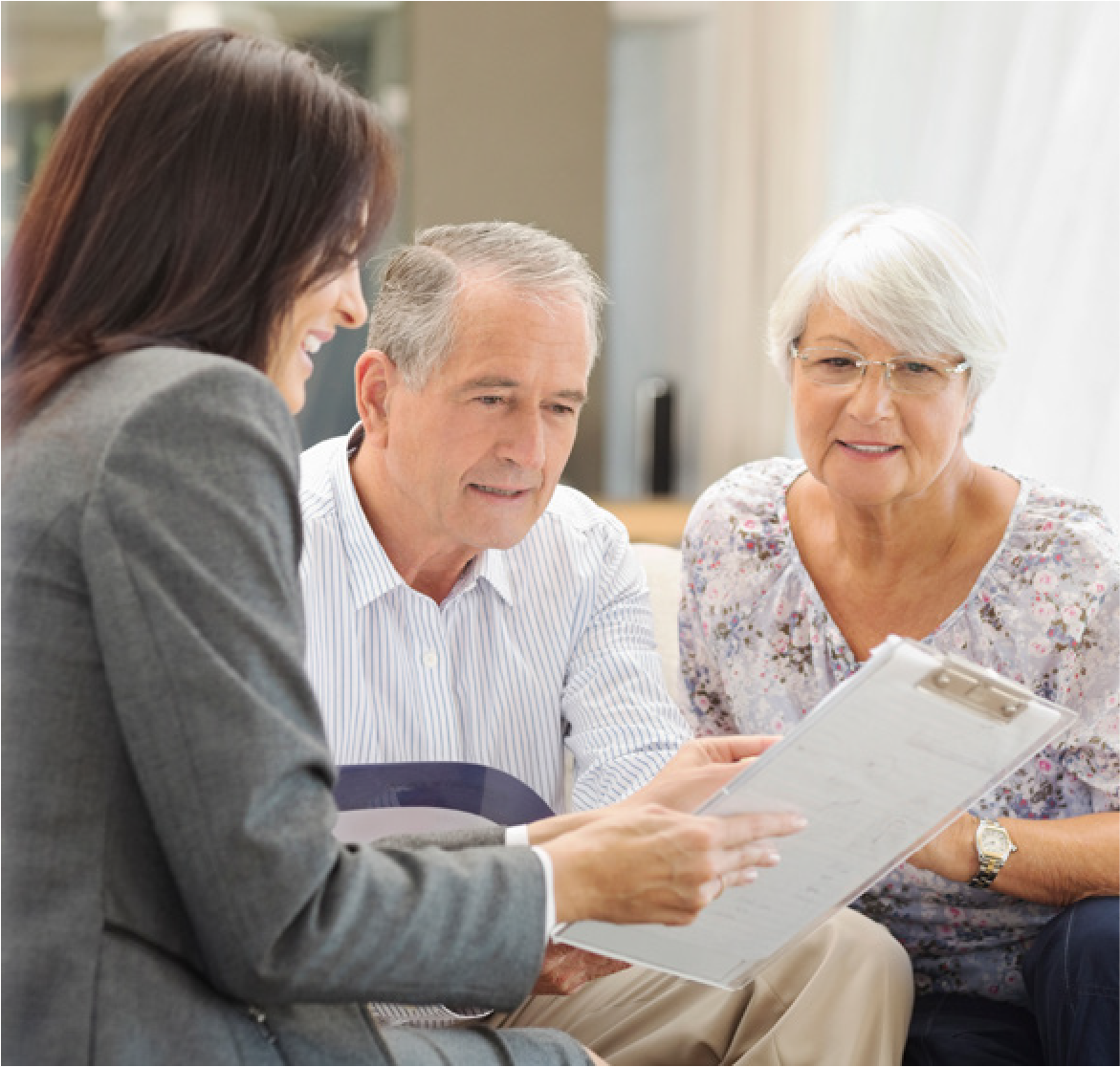 Couple in their 70s talking with their financial professional and looking over documents.