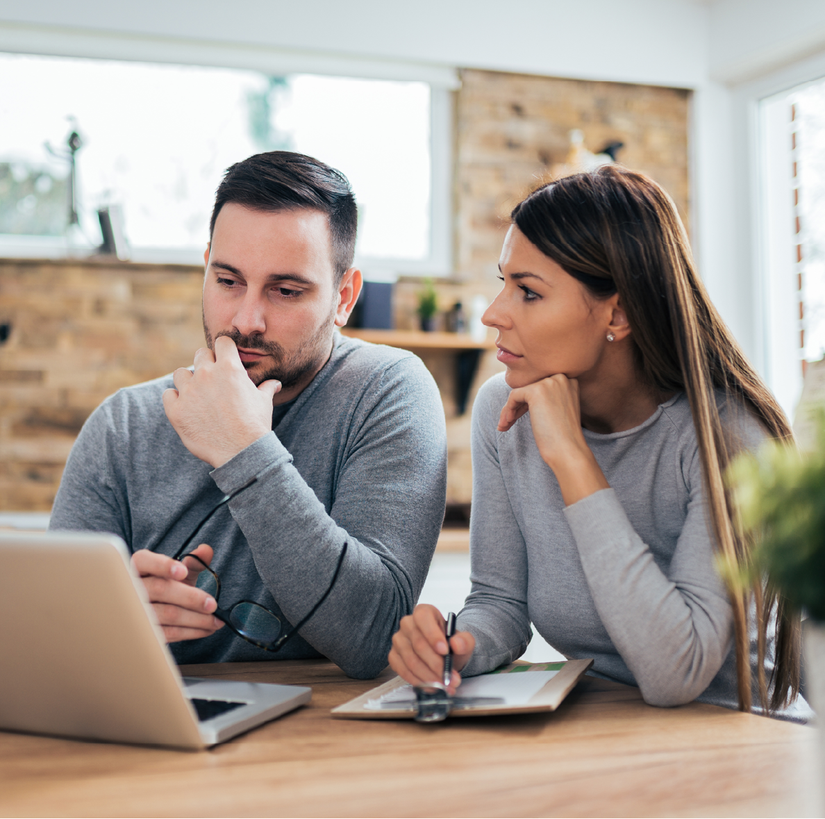 Man and woman sitting at a desk looking at a computer.