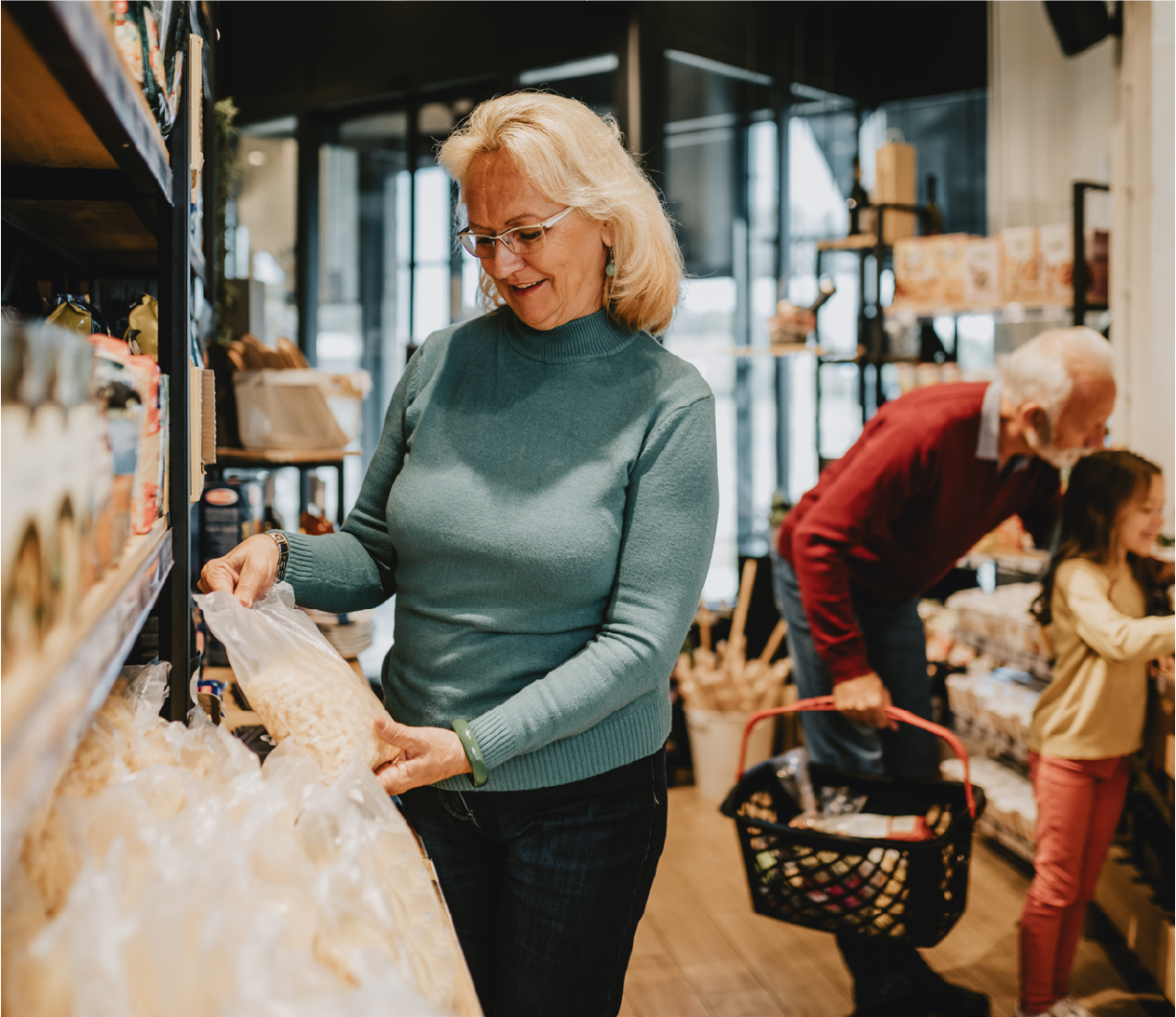 Woman grabbing a bag of cereal in the grocery store and smiling.